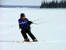 Буксировка лыжников и сноубордеров за снегоходом по замершему озеру